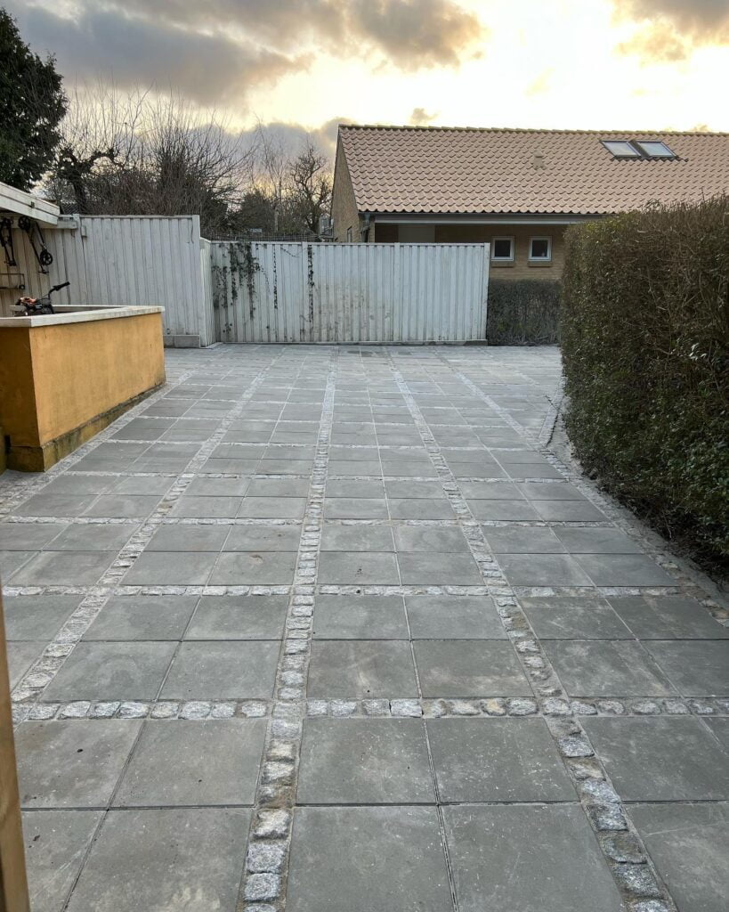 Nyfliseret gårdhave med hæk og plankeværk