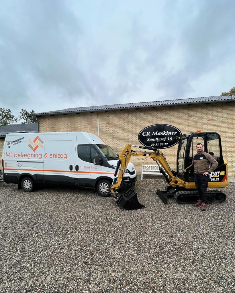 Mand ved minigraver foran ML belægning og anlæg varevogn